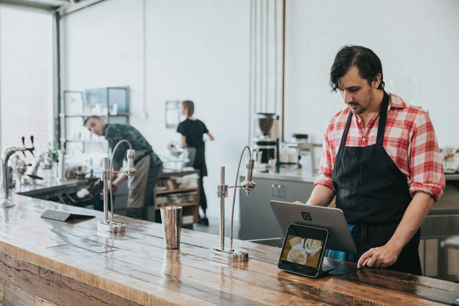 An owner checking orders on a tablet at the counter
